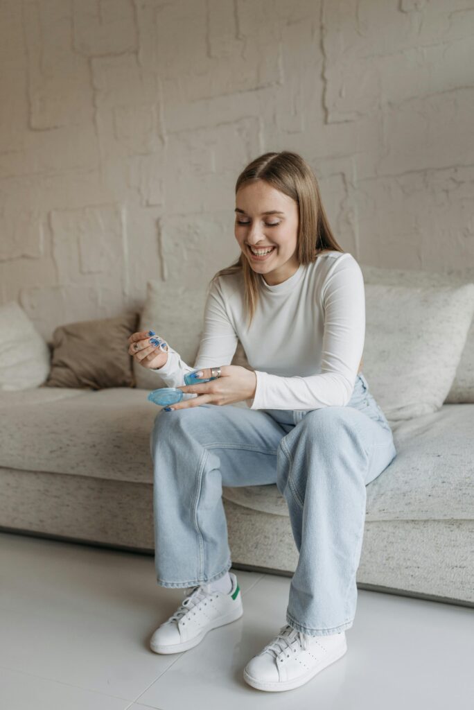 pexels-photo-7653661-7653661 Happy woman sitting on sofa holding pH paper in a cozy living room.